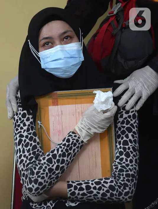 Tangis keluarga korban kecelakaan Sriwijaya Air SJ 182 saat serah terima jenazah di RS Polri, Jakarta, Kamis (14/1/2021). Jenazah atas nama Okky Bisma menjadi korban kecelakaan Sriwijaya Air SJ 182 pertama yang berhasil teridentifikasi oleh tim DVI. (merdeka.com/Imam Buhori)