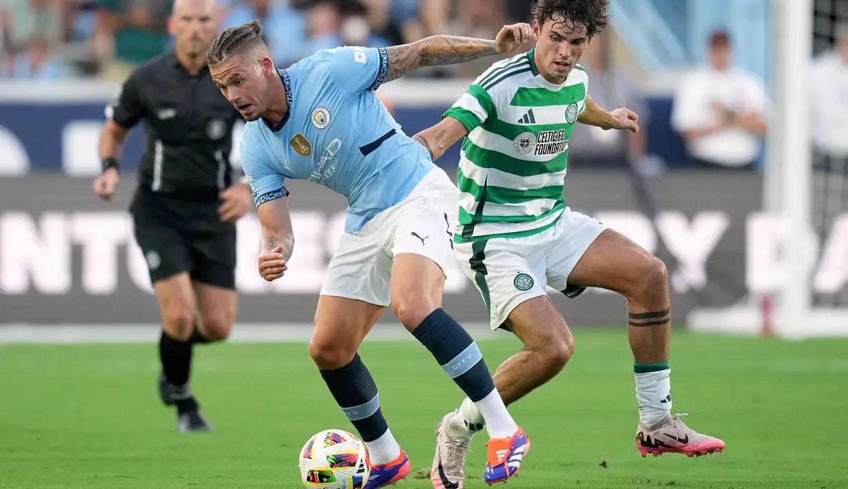 Gelandang Manchester City Kalvin Phillips berebut bola dengan gelandang Glasgow Celtic, Matt O'Riley dalam pertandingan uji coba di Stadion Kenan Momorial, Amerika Serikat, Rabu (24/7/2024) pagi WIB. (GRANT HALVERSON / GETTY IMAGES NORTH AMERICA / Getty Images via AFP)