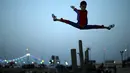 Aksi akrobat Mohammed al Sheikh melompat ke atas, di sebuah pantai di Kota Gaza, Palestina, Kamis (2/6). Remaja 12 tahun itu menyatakan keinginannya untuk mencetak rekor dunia Guinness World Record yang baru. (REUTERS/Mohammed Salem)