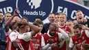 Striker Arsenal, Pierre-Emerick Aubameyang (tengah) menjatuhkan trofi saat merayakan gelar juara Piala FA usai mengalahkan Chelsea pada pertandingan final Piala FA di stadion Wembley, Minggu (2/8/2020).  Aubameyang terlihat kaget sambil memegang kepalanya saat trofi terjatuh. (Adam Davy/Pool via AP)