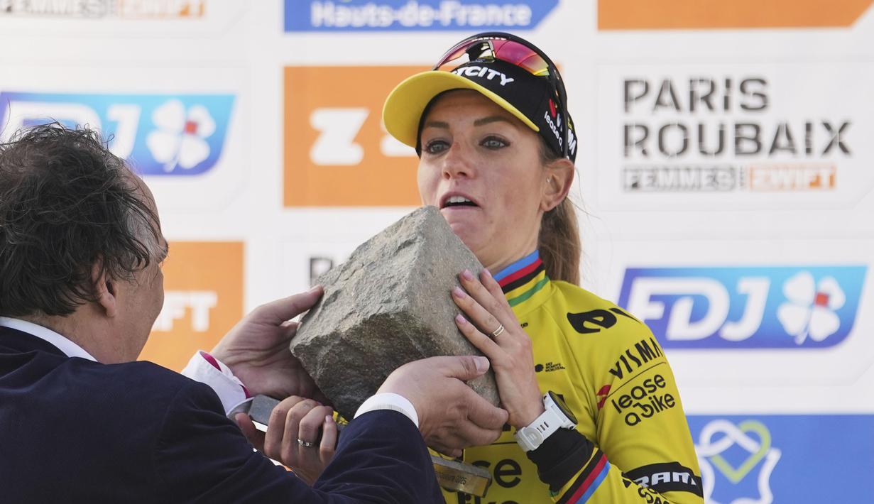 Ekspresi keberatan pembalap Team Visma-Lease, Pauline Ferrand-Prevot saat menjunjung trofi kemenangan Paris Roubaix Femmes 2025 pada Sabtu (12/04/2025) waktu setempat. Perlombaan tersebut menempuh 148,5 km dari Denain hingga Roubaix, Prancis. (AP Photo/Thibault Camus)