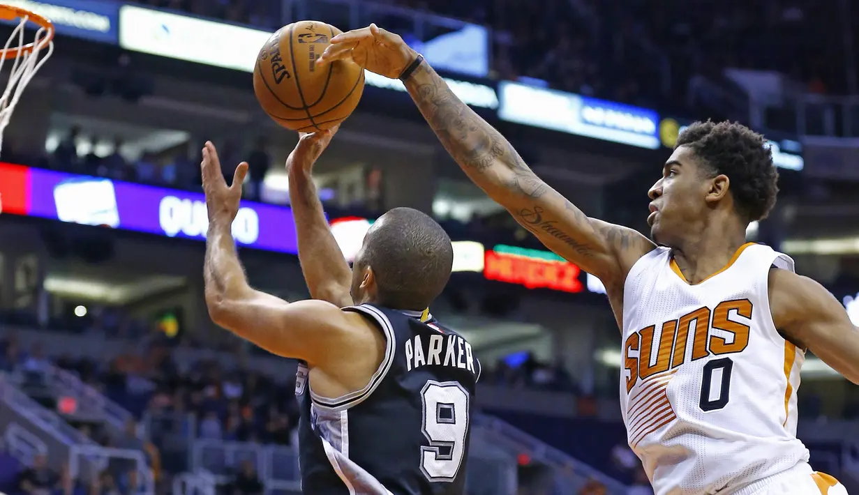 Pemain Phoenix Suns,  Marquese Chriss (kanan) mencoba mamblok tembakan pemain San Antonio Spurs, Tony Parker (kiri) pada laga NBA di Talking Stick Resort Arena, (15/12/2016). Spurs menang 107-92. (AP/Ross D. Franklin)