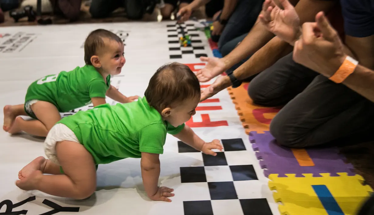 Dua kontestan bayi hampir mencapai garis akhir saat mengikuti lomba merangkak dalam Diaper Derby NYC triathlon di New York City (14/7). Sekitar 30 bayi ikut serta dalam perlombaan tersebut. (AFP Photo/Dominick Reuter)