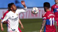 Gelandang Real Madrid, Casemiro, berebut bola dengan pemain Elche, Tete Morente, pada laga Liga Spanyol di Stadion Alfredo di Stefano, Sabtu (13/3/2021). Real Madrid menang dengan skor 2-1. (AP/Bernat Armangue)