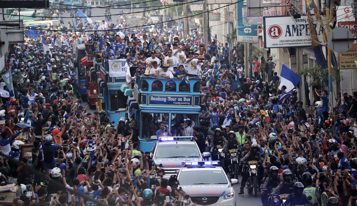 Warga Bandung menyambut pemain Persib di sepanjang rute yang dilalui saat berlangsungnya Pawai Persib Juara Piala Presiden, Minggu (25/10/2015). (Bola.com/Nicklas Hanoatubun)