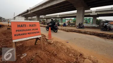 Sebuah papan peringatan terpasang di sisi ruas jalan inspeksi Kalimalang, Jakarta, Selasa (14/6/2016). Jelang arus mudik Lebaran 2016, sebagian ruas jalan inspeksi Kalimalang masih terlihatrusak dan berlubang. (Liputan6.com/Helmi Fithriansyah)