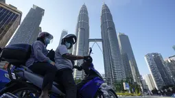 Pengemudi menunggu di depan Menara Kembar pada hari pertama Perintah Kontrol Gerakan Penuh (MCO) di Kuala Lumpur, Malaysia (1/6/2021). Penguncian kedua dilakukan untuk mengatasi pandemi yang memburuk yang telah menempatkan sistem perawatan kesehatannya di ambang kehancuran. (AP Photo/Vincent Thian)