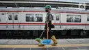 Pekerja saat bertugas membersihkan area peron di Stasiun Manggarai, Jakarta, Senin (27/12/2021). Pemprov DKI resmi menetapkan upah minimum provinsi (UMP) 2022 naik 5,1 persen atau menjadi Rp4.641.854. (merdeka.com/Iqbal S Nugroho)