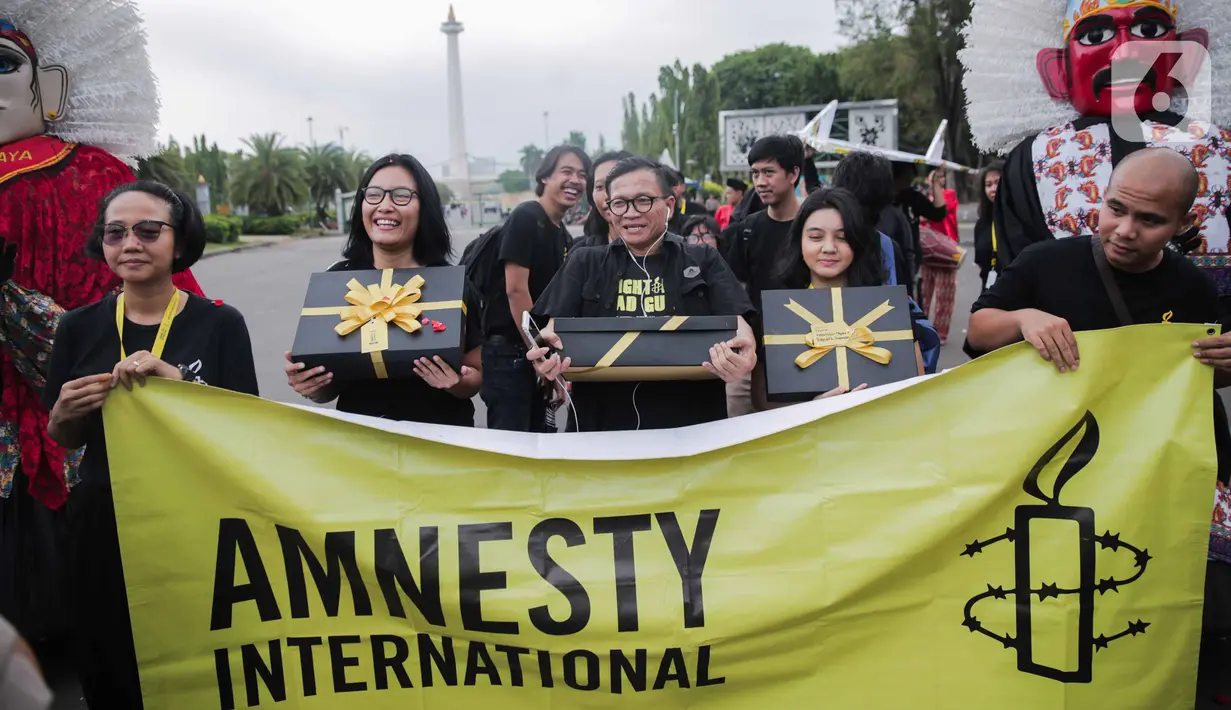 Aktivis yang tergabung dalam Amnesty Internasional Indonesia menggelar aksi di depan Istana Negara, Jakarta, Selasa (10/12/2019). Aksi tersebut digelar untuk memperingati Hari HAM Sedunia 2019. (Liputan6.com/Faizal Fanani)