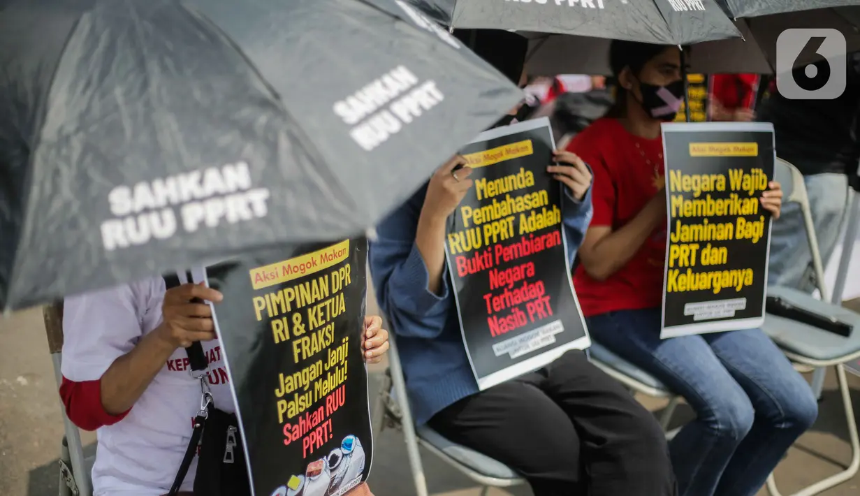 PRT juga menggunakan payung hitam dengan tulisan 'Sahkan RUU PPRT'. (Liputan6.com/Faizal Fanani)
