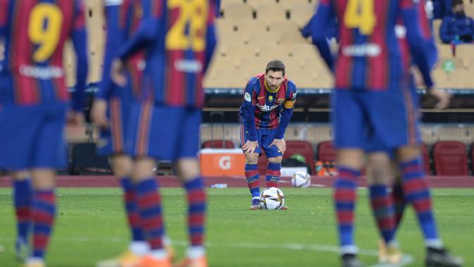 Penyerang Barcelona, Lionel Messi bersiap untuk menembak saat bertanding melawan Athletic Bilbao pada final Piala Super Spanyol di stadion La Cartuja, Senin (18/1/2021). Terkait pasal tersebut, La Pulga disebut bisa absen baik di ajang La Liga Spanyol maupun ajang Copa del Rey. (AFP/Cristina Quicler