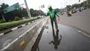 Pengendara Gojek bernama Ari mencari ranjau paku yang berserakan di sekitar Istana Negara, Jakarta, Minggu (14/8). Meskipun tak dibayar, Ari berinisiatif untuk mengumpulkan ranjau paku yang merugikan pengendara tersebut. (Liputan6.com/Immanuel Antonius)