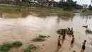 Anak-anak menaruh jaring di derasnya arus Sungai Ciliwung, Rawajati, Jakarta, Selasa (6/2). Meski sedang meluap, hal tersebut tidak menyurutkan niat anak-anak untuk beraktivitas di sekitar sungai. (Liputan6.com/Immanuel Antonius)