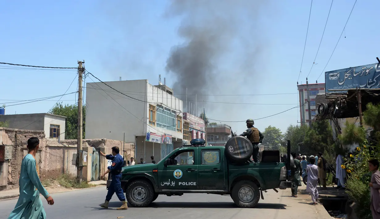 Personel keamanan Afghanistan memblokade jalan dekat ledakan bom bunuh diri di Jalalabad, Selasa (31/7). Pria bersenjata menyerang gedung pemerintahan, membuat puluhan orang terperangkap setelah pelaku meledakkan bom bunuh diri. (AFP/NOORULLAH SHIRZADA)