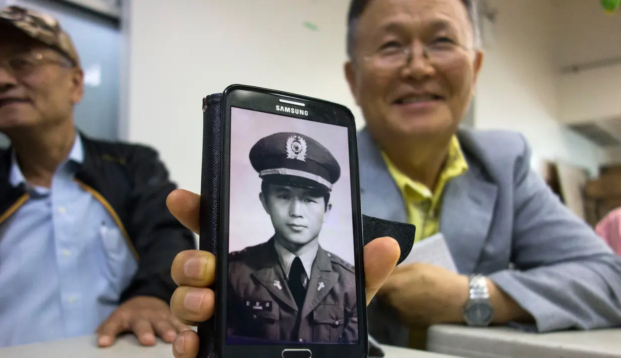 Kwang Sup Jang (kanan) menunjukkan foto dirinya sebagai pendeta di pusat Layanan Komunitas Korea di New York (10/8).  Kwang Sup Jang bekerja sebagai pendeta di militer Korea dan menghabiskan tiga tahun di Zona Demiliterisasi Korea.(AFP Photo/Don Emmert)