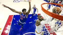 Pemain Cleveland Cavaliers, LeBron James (kanan), melewati pemain Philadelphia 76ers, Joel Embiid, untuk mencetak angka dalam laga NBA di Philadelphia, (5/11/2016). (AP Photo/Chris Szagola)