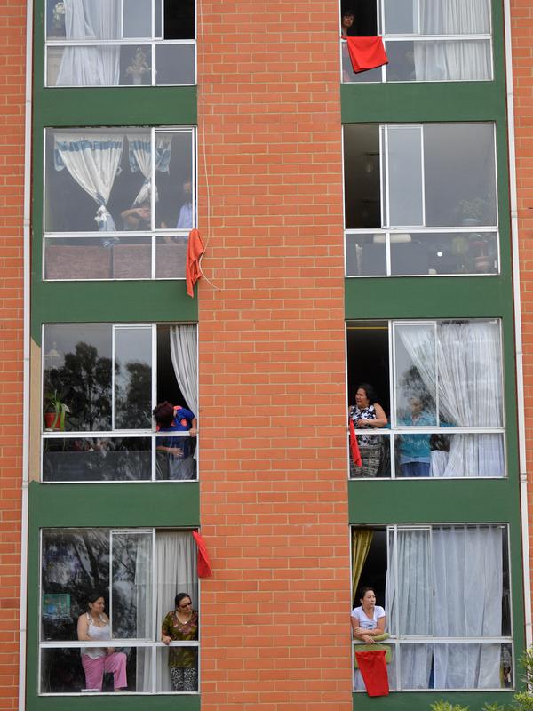 Orang-orang menggantungkan kain merah di rumah mereka untuk meminta bantuan makanan selama lockdown di kotamadya Soacha, dekat Bogota, 4 April 2020. Presiden Kolombia Ivan Duque menetapkan lockdown dari 24 Maret hingga 13 April sebagai langkah mencegah penyebaran virus corona. (Raul ARBOLEDA/AFP)