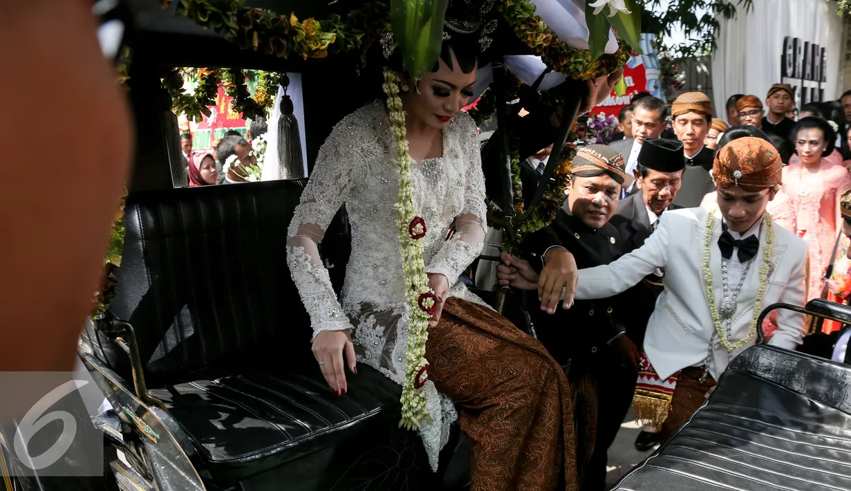Pasangan pengantin Gibran-Selvi saat berada di kereta kuda usai resepsi pernikahannya dan akan menuju kediaman Gibran di Jalan Kutai Utara RT.08/RW.07 Sumber, Solo, Jateng, Kamis (11/6/2015). (Liputan6.com/Faizal Fanani)