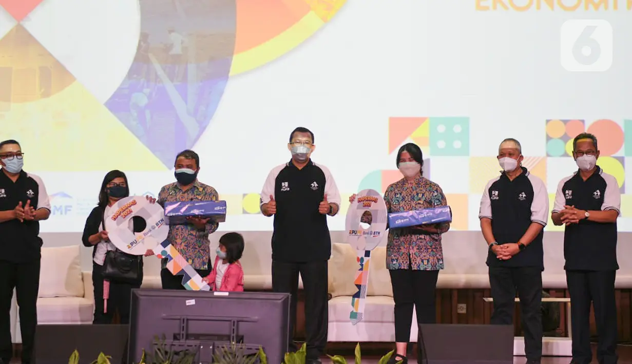 Direktur Utama PT Bank Tabungan Negara Haru Koesmahargyo (tengah), didampingi Dirjen Kementerian PUPR dan Komisioner BP Tapera usai penyerahan secara simbolis  kunci rumah kepada keluarga karyawan honorer di Jakarta, Rabu (25/8/2021). (Liputan6.com/HO/Satria)