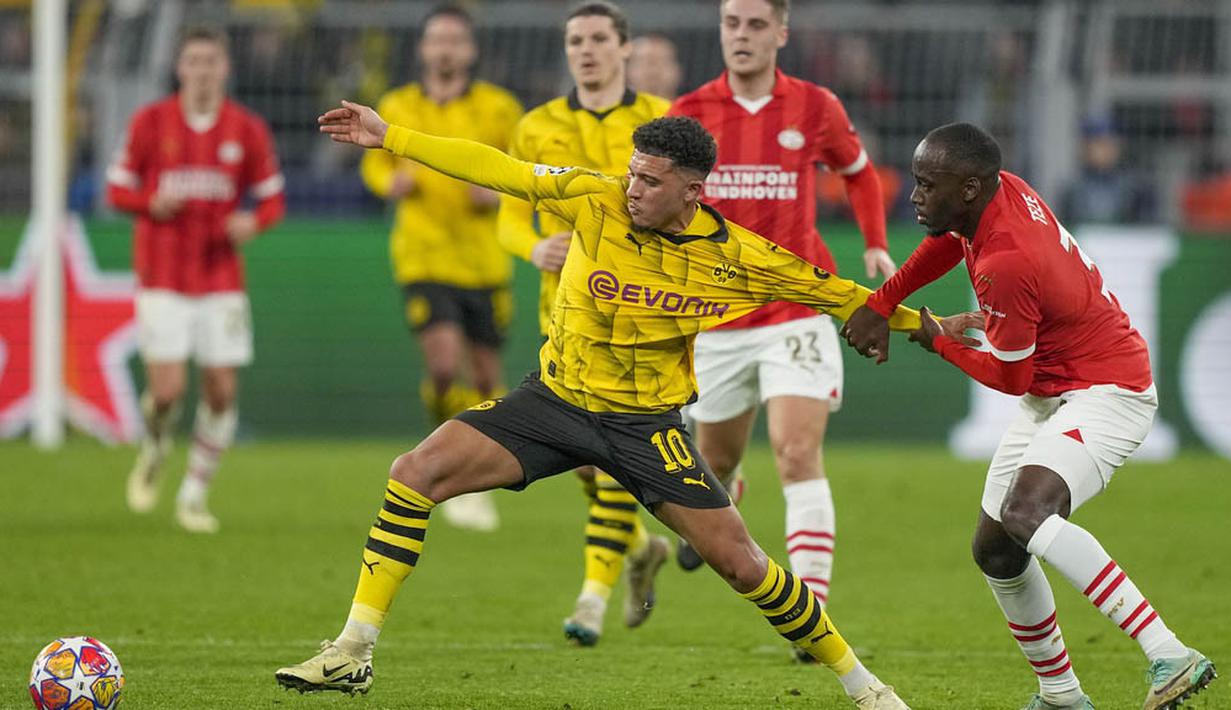 Pemain Borussia Dortmund, Jadon Sancho, berebut bola dengan pemain PSV Eindhoven, Jordan Teze, pada laga leg kedua babak 16 besar Liga Champions di Stadion Signal Iduna Park, Rabu (13/3/2024). (AP Photo/Martin Meissner)