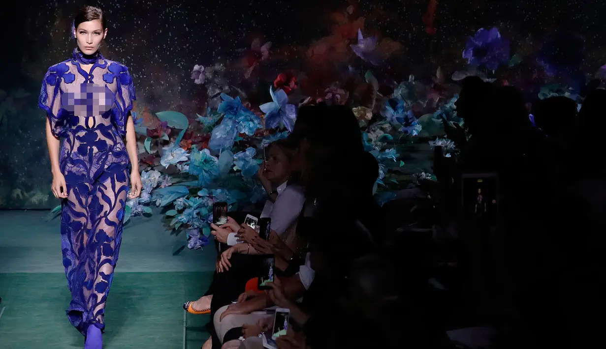 Model asal AS, Bella Hadid berjalan di atas catwalk membawakan busana rancangan Karl Lagerfeld untuk rumah mode Fendi di Paris, Prancis, (5/7). Bella Hadid tampil cantik dengan gaun berwarna biru menerawang. (AFP Photo/Patrick Kovarik)