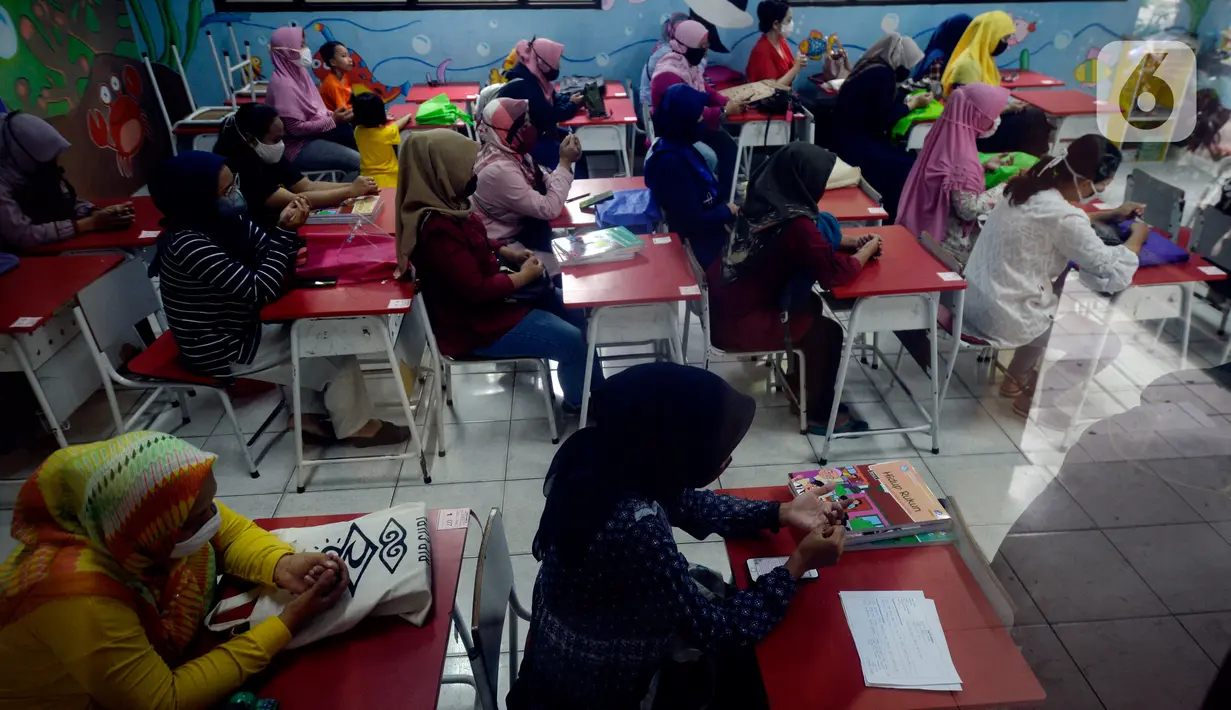 Orang Tua Siswa SDN Serua 3 kelas 2 dan 3 mendengarkan pengarahan guru tentang tata cara belajar mengajar online tahun ajaran baru serta pembagian buku gratis di Bukit, Ciputat, Tangerang Selatan, Banten, Rabu (15/7/2020). (merdeka.com/Dwi Narwoko)