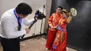 Pasangan pengantin asal Tiongkok mengenakan baju tradisional berfoto saat mengikuti pernikahan massal di Kolombo, Sri Lanka (17/12). Acara nikah massal ini juga bertujuan untuk meningkatkan pariwisata di Sri Lanka. (AFP Photo/Ishara S. Kodikara)