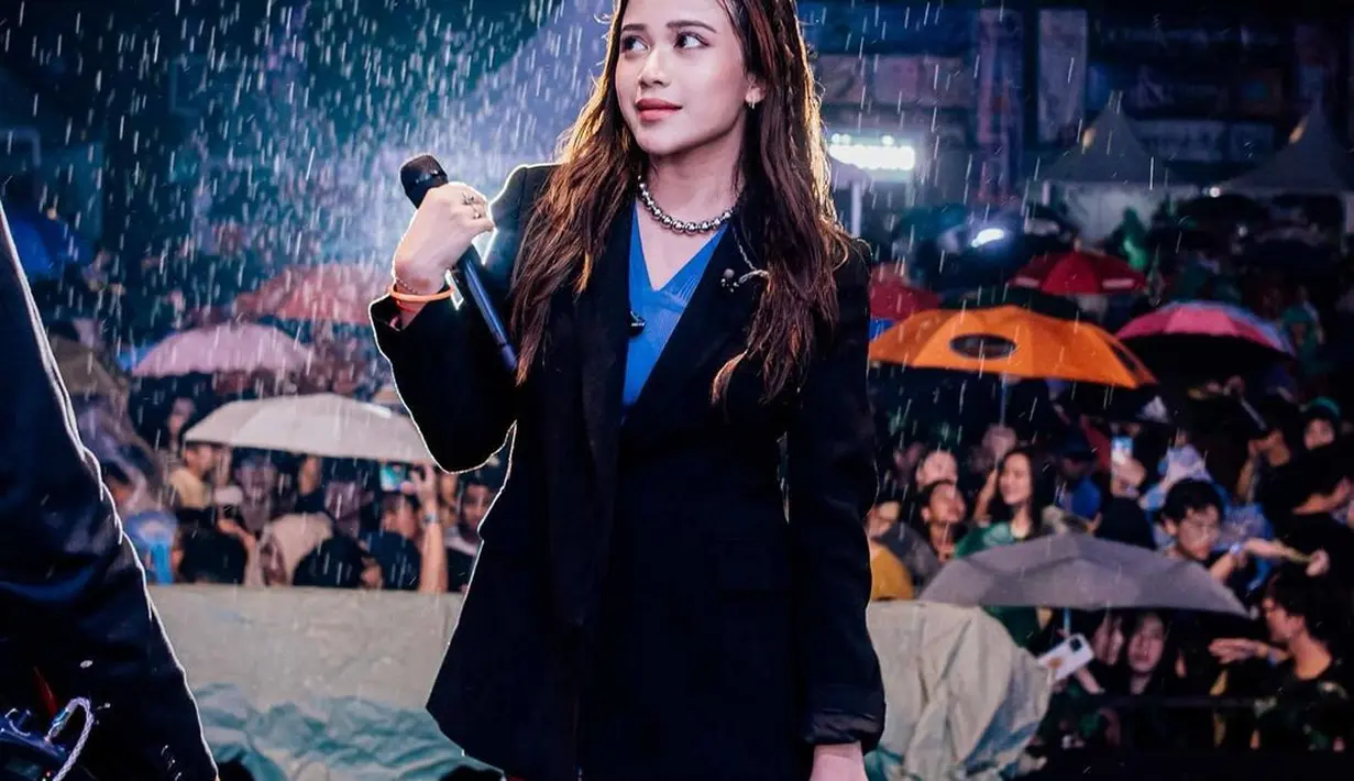 Lagi, manisnya penampilan Brisia Jodie di tengah hujan. Ia mengenakan inner biru yang ditumpuknya dengan oversized blazer hitam. [Foto: Instagram/brisiajodie96]