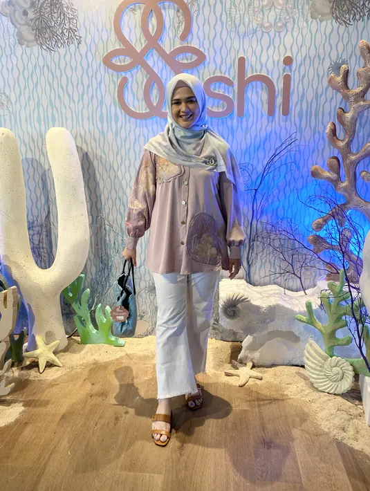 Cut Meyriska tampil dengan kemeja warna ungu dipadukan kerudung segi empat warna hijau bermotif dan celana putihnya.