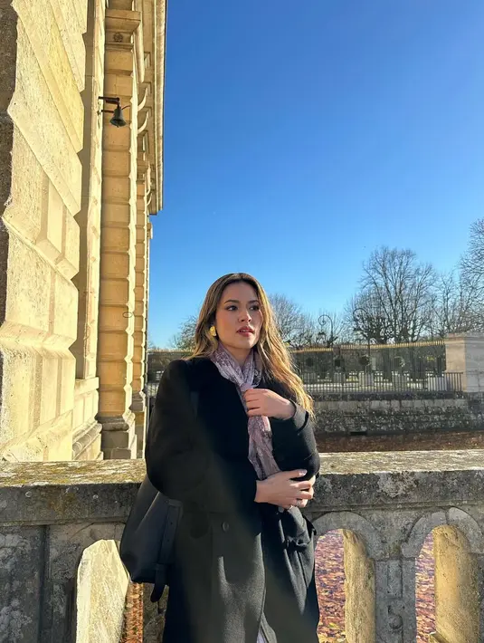 Dalam salah satu potret yang diunggah di media sosial, Raisa terlihat mengenakan long coat hitam dan rok plisket warna putih yang memberikan kesan klasik dan mewah. [@raisa6690].