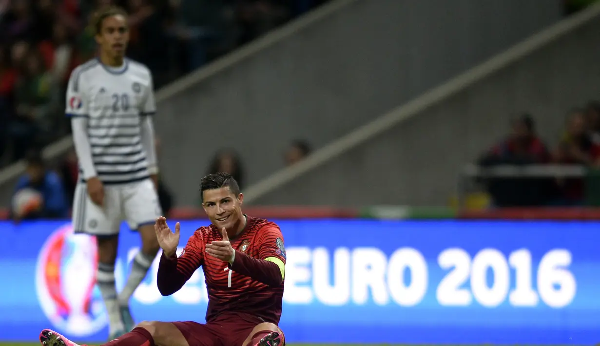 Bintang Portugal Cristiano Ronaldo bertpuk tangan saat terjatuh pada laga Kualifikasi Piala Eropa 2016 Grup I di Municipal stadium, Braga, Kamis (8/10/2015). Portugal menang atas Denmark1-0. (AFP Photo/ Miguel Riopa)