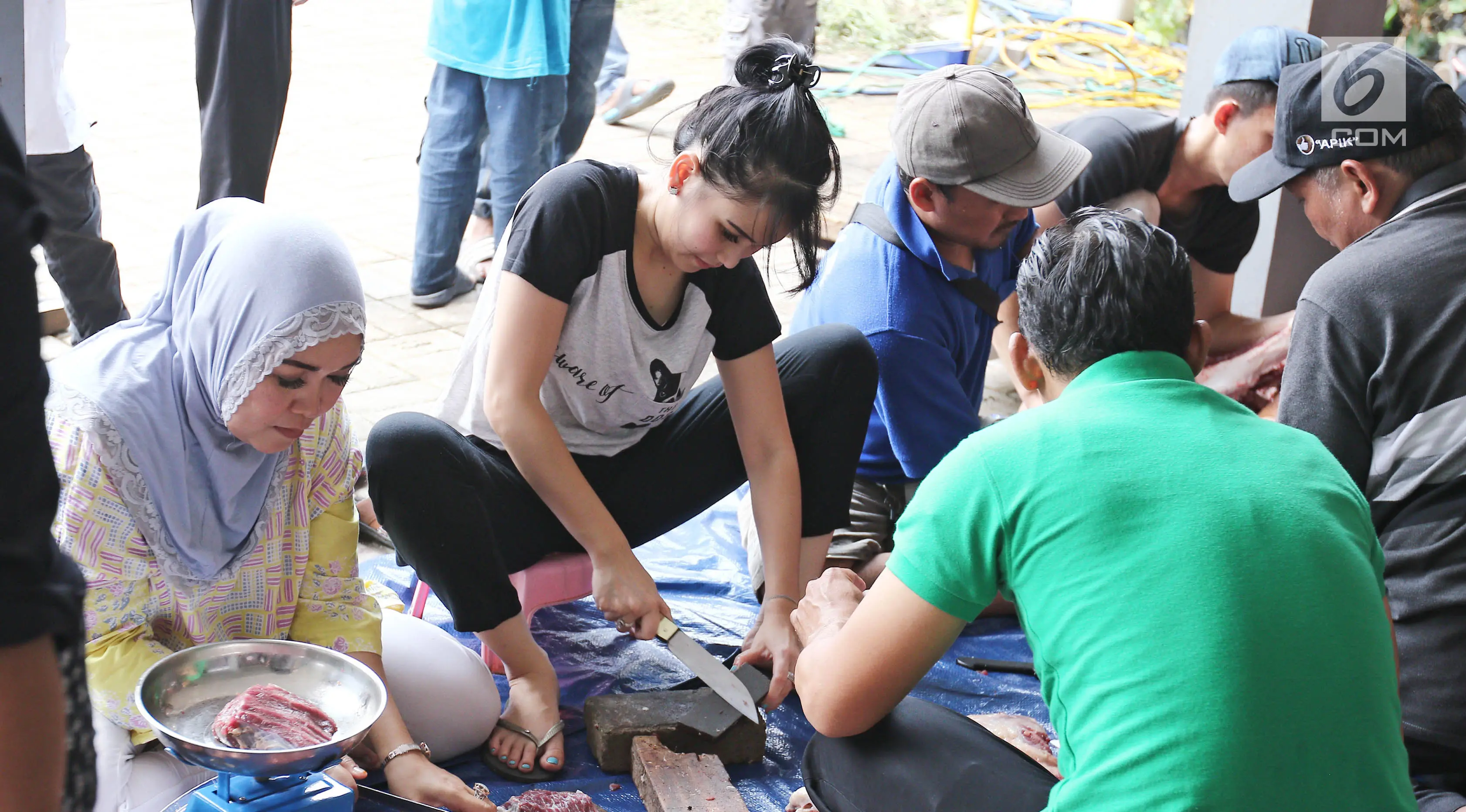 Penyanyi dangdut Ayu Ting Ting mengasah pisau untuk memotong daging kurban di kediamannya, Depok (1/9). Pada tahun ini Ayu Ting Ting berkurban sapi sebanyak 3 ekor di kediamannya. (Liputan6.com/Herman Zakharia)