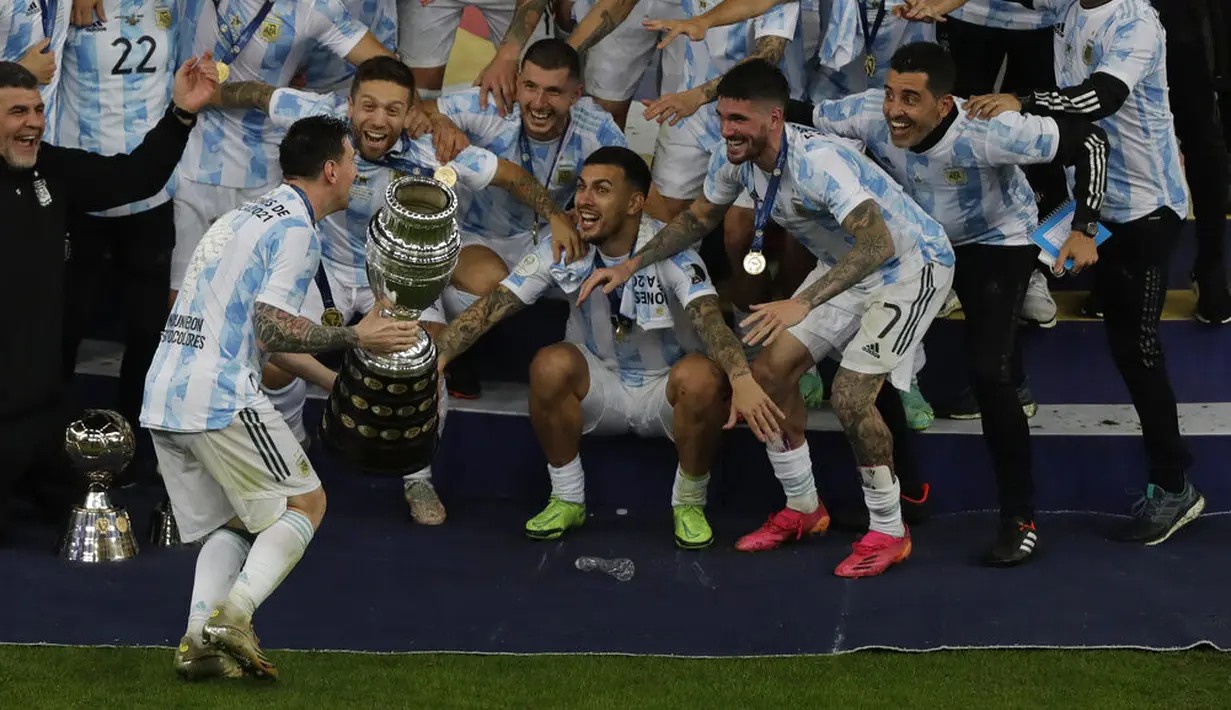 Penyerang Argentina, Lionel Messi merayakan trofi Copa America 2021 usai mengalahkan Brasil 1-0 di final di stadion Maracana, Brasil, Minggu (11/7/2021). Lewat gelar ini, Messi juga sukses mengakhiri puasa gelar Argentina di ajang Copa America. (AP Photo/Silvia Izquierdo)