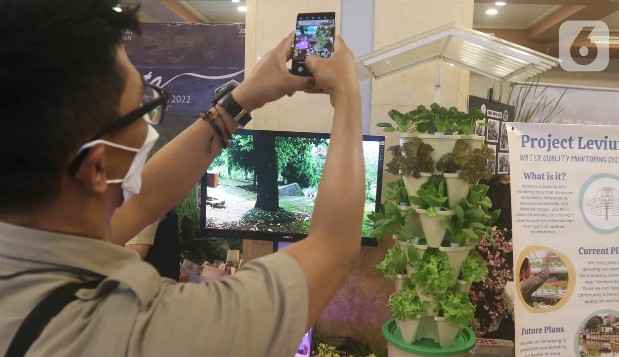 Pengunjung mengambil gambar pameran Jakarta Innovation Day 2022 di Balai Kota DKI Jakarta, Selasa (27/9/2022). Pemerintah Provinsi (Pemprov) DKI Jakarta menggelar Jakarta Innovation Day 2022, dalam ajang pameran innovasi Jakarta terdapat Bioniqa yaitu pohon robot yang mampu mereduksi karbon di udara dan mengubahnya menjadi oksigen. (Liputan6.com/Herman Zakharia)