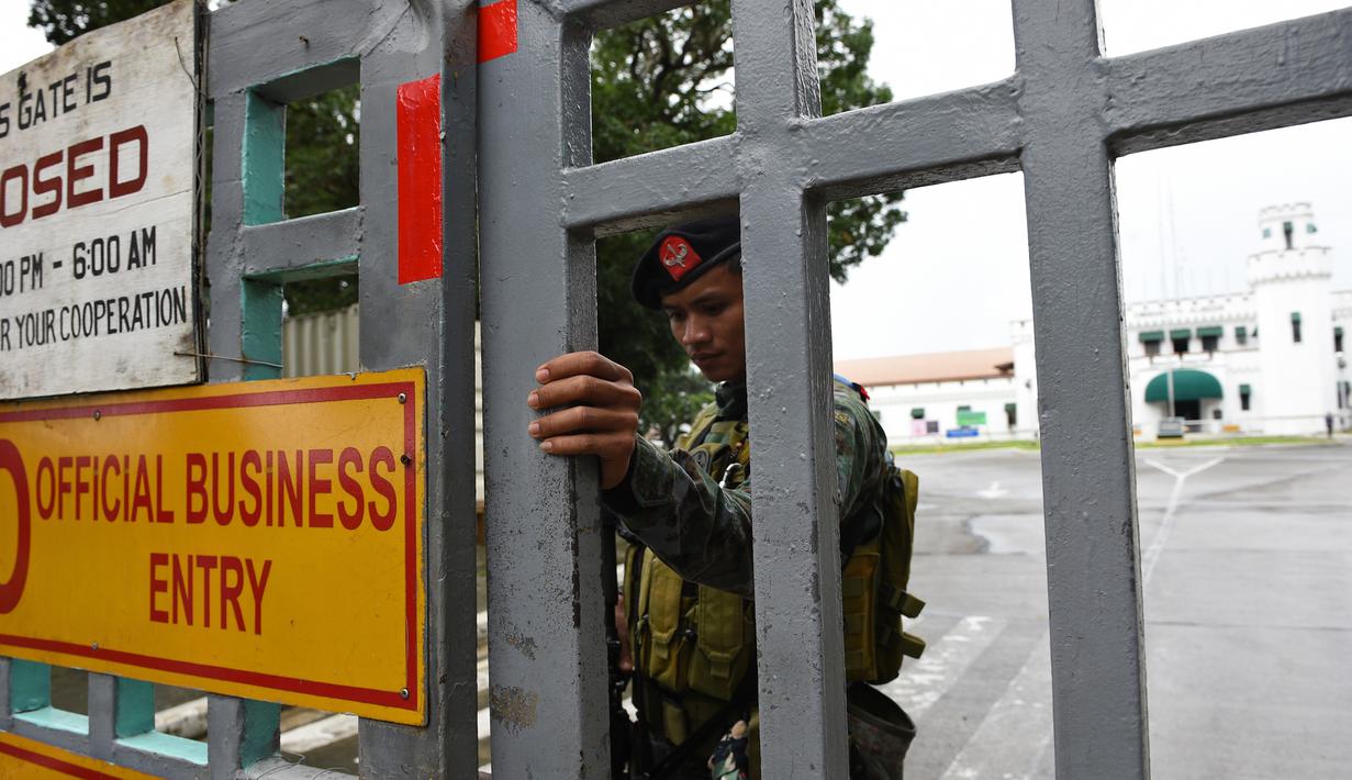 Polisi pasukan khusus berdiri di gerbang sebuah penjara di Filipina usai insiden kerusuhan, Rabu (28/9). Satu anggota geng narkoba tewas dan tiga napi terluka dalam kerusuhan di penjara yang terkenal dengan kekerasan dan kekejamannya. (TED Aljibe/AFP)