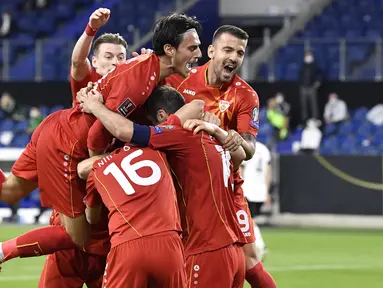 Para pemain Makedonia Utara merayakan gol pertama ke gawang Jerman yang dicetak striker Goran Pandev dalam laga lanjutan Kualifikasi Piala Dunia 2022 Zona Eropa Grup J di Duisburg, Jerman, Rabu (31/3/2021). Makedonia Utara mengalahkan Jerman 2-1. (AP/Martin Meissner)
