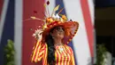 Rebecca Johnson berpose untuk para fotografer dengan mengenakan topi hiasan pada hari pertama pacuan kuda Royal Ascot di Ascot, Inggris, Selasa (15/6/2021). Balap kuda eksklusif yang hanya dihadiri oleh kalangan elit Inggris itu menjadi tradisi tahunan sejak tahun 1711. (AP Photo/Alastair Grant)