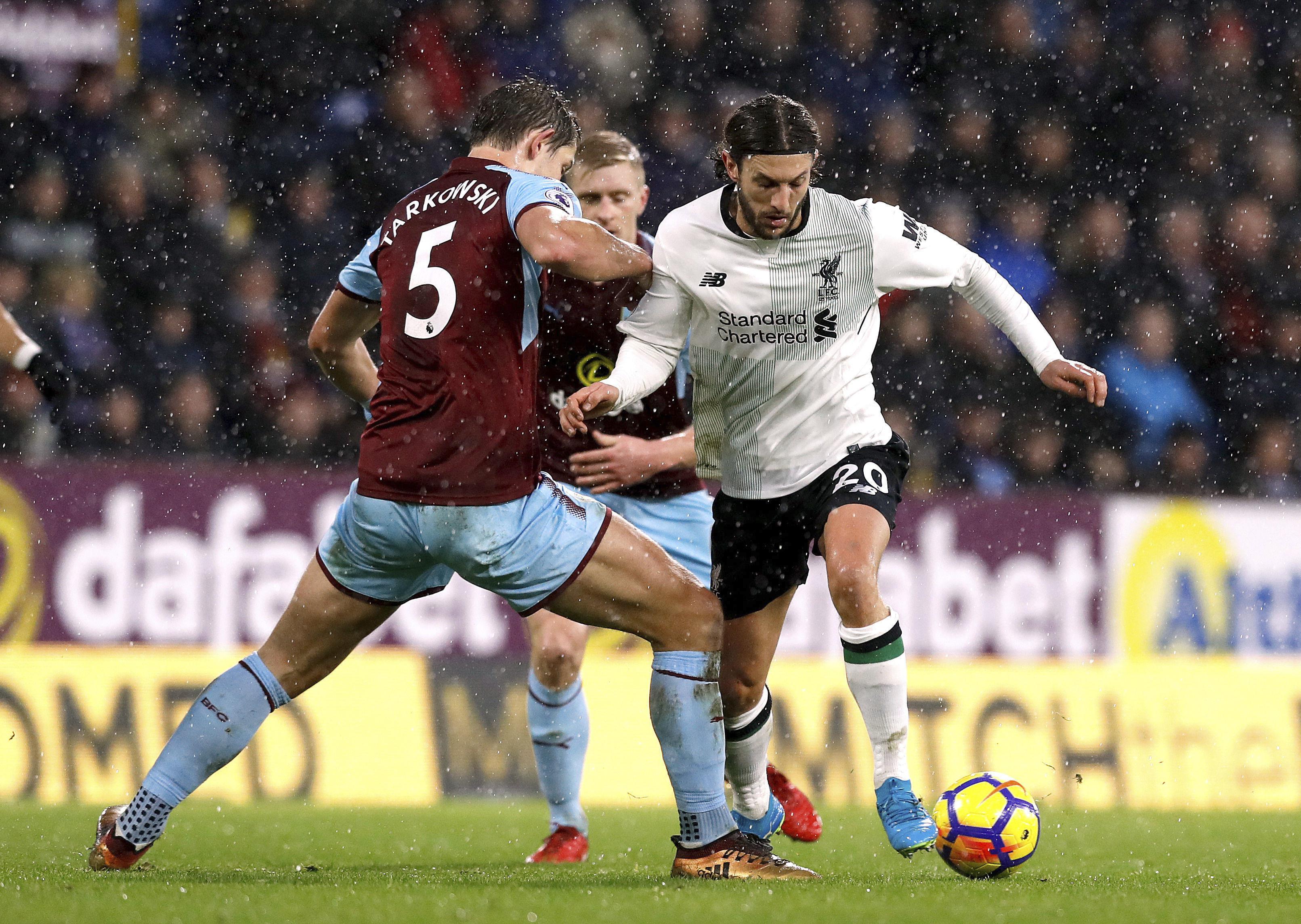Gelandang Liverpool Adam Lallana (kanan) berduel dengan bek Burnley James Tarkowski pada laga Liga Inggris di Turf Moor, Senin (1/1/2018). (AP/Martin Rickett)