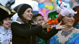 Aktris Mila Kunis menerima boneka saat diarak dalam sebuah parade di Cambridge (25/1). Hasty Pudding sendiri adalah kelompok teater yang berasal dari Universitas Harvard. (AP Photo / Charles Krupa)