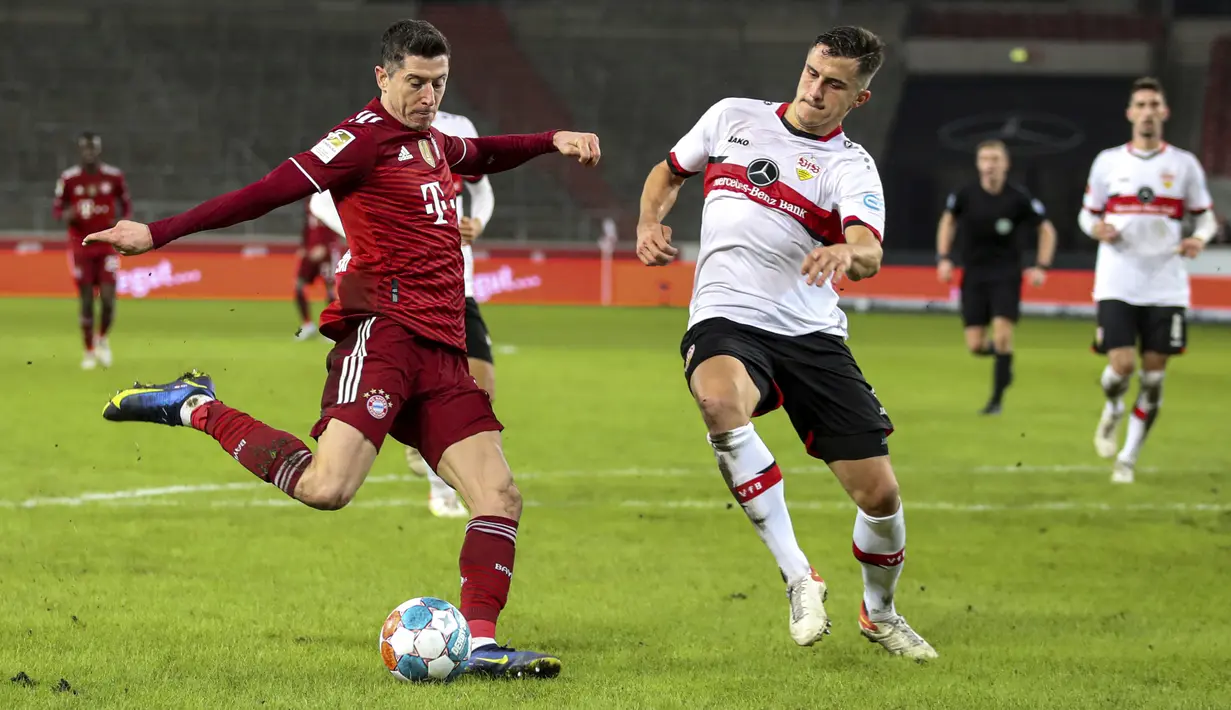 Penyerang Bayern Munchen Robert Lewandowski berebut bola dengan bek VfB Stuttgart, Marc Oliver Kempf pada lanjutan Liga Jerman di Mercedes-Benz Arena, Rabu (15/12/2021) dinihari WIB. Bayern Munchen sukses melumat VfB Stuttgart dengan skor 5-0. (Tom Weller/dpa via AP)