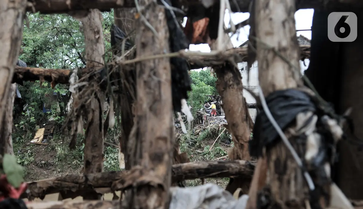 Kondisi tanggul kayu yang rusak dan penuh sampah di bantaran Kali Ciliwung, Rawajati, Pancoran, Jakarta, Minggu (5/1/2020). Tanggul dari kayu dolken dan karung pasir yang baru dibangun pada akhir Desember 2019 itu rusak hingga dipenuhi sampah akibat terjangan arus banjir. (merdeka.com/Iqbal Nugroho)