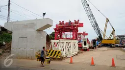 Pedagang melewati proyek pembangunan jalur dua rel ganda Manggarai-Cikarang, Jakarta, Jumat (13/1). Kemenhub akan bekerjasama dengan Pemda DKI untuk membantu mempercepat pembebasan lahan tersebut. (Liputan6.com/Gempur M Surya)