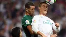 Striker Real Madrid, Cristiano Ronaldo, duel udara dengan bek Real Betis, Morocco Zou pada laga La Liga Spanyol di Stadion Santiago Bernabeu, Rabu (20/9/2017). Real Madrid kalah 0-1 dari Real Betis. (AFP/Gabriel Bouys)