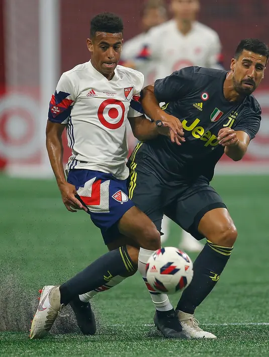 Pemain MLS All-Stars Tyler Adams berebut bola dengan pemain Juventus Sami Khedira saat bertanding pada MLS All-Star Game 2018 di Mercedes-Benz Stadion, Atlanta, Georgia (1/8). Juventus menang 5-3. (AFP Photo/Kevin C. Cox)
