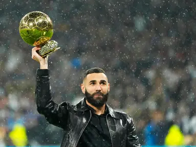 Pemain Real Madrid Karim Benzema memegang trofi Ballon d'Or 2022 sebelum pertandingan sepak bola Liga Spanyol antara Real Madrid dan Sevilla di Stadion Santiago Bernabeu, Madrid, Spanyol, 22 Oktober 2022. Karim Benzema meraih Ballon d’Or 2022 setelah sukses mengungguli Sadio Mane, Kevin De Bruyne, Robert Lewandowski, hingga Mohamed Salah. (AP Photo/Manu Fernandez)