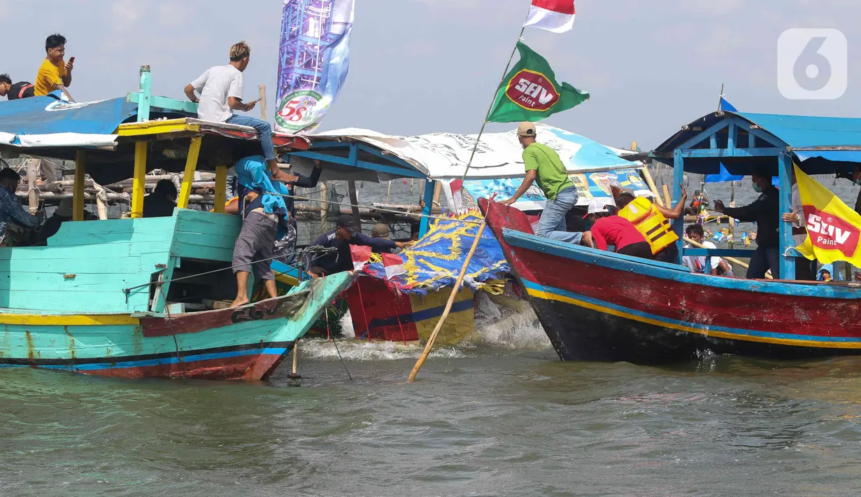 Sejumlah nelayan bersiap untuk melarung replika kapal berisi sesaji di Pantai Tarumajaya, Kabupaten Bekasi, Jawa Barat, Jumat (28/1/2022). Ritual ini diikuti sebanyak 40 kapal nelayan dari enam Muara. (Liputan6.com/Herman Zakharia)