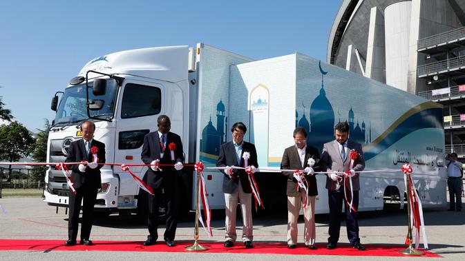 Para tamu memotong pita saat peresmian truk masjid di Toyota Stadium, Jepang, Senin (23/7). Truk masjid untuk Olimpiade 2020 ini berkapasitas hingga 50 orang. (Mobile Mosque Executive Committee via AP)