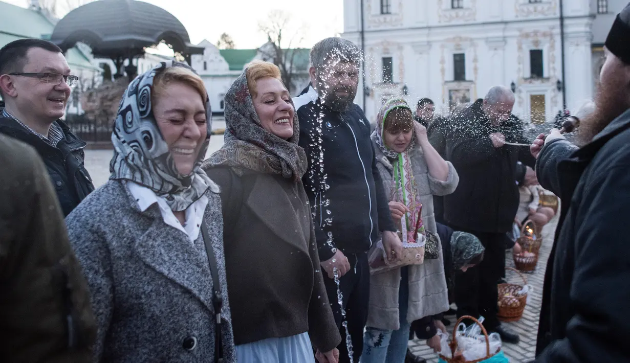 Imam Ortodoks Ukraina mencipratkan air saat memberkati jemaatnya dalam perayaan Paskah di Biara Volodymyrskiy di Kiev, Ukraina (8/4). (AP Photo / Evgeniy Maloletka)