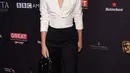Aktris Emma Watson berpose saat menghadiri BAFTA Los Angeles Awards Season Tea Party di Four Season Hotel di Beverly Hills, California, (6/1). Emma Watson tampil kasual dengan kemeja putih, celana dan sepatu hitam. (AFP Photo/Chris Delmas)