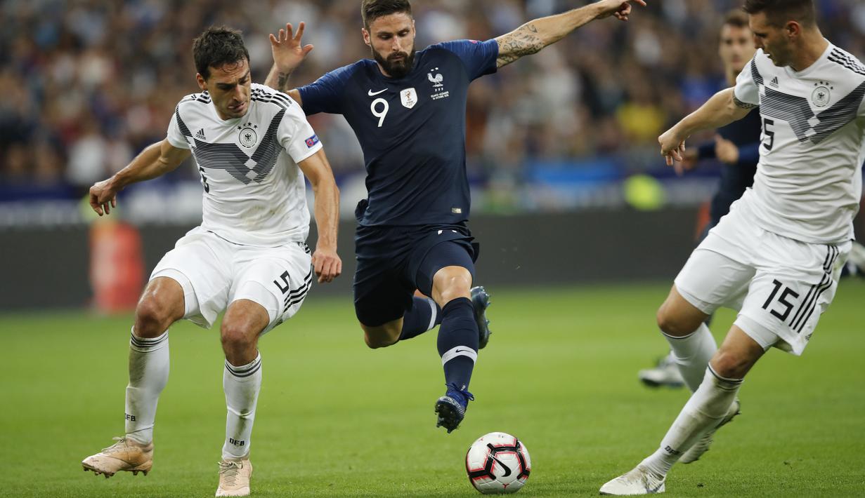 Penyerang Prancis, Olivier Giroud, berusaha melewati pemain Jerman pada laga UEFA Nations League di Stade de France, Paris, Selasa (16/10/2018). Prancis menang 2-1 atas Jerman. (AP/Christophe Ena)